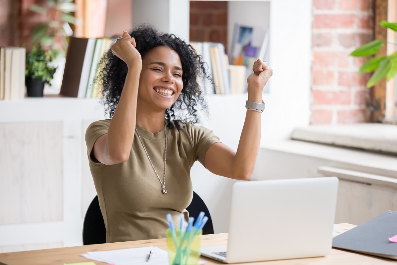 A happy woman cheering with her arms in the air